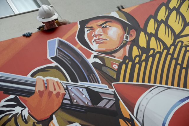 ایک مزدور فلم کے پوسٹر کو ہٹاتا ہوا دیکھا جا سکتا ہے