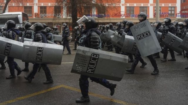 Riot police officers patrol in a street during rally over a hike in energy prices in Almaty