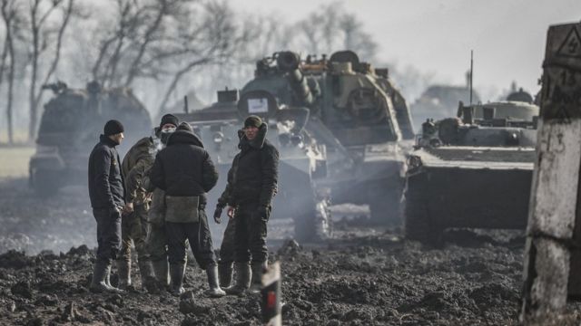 Russian servicemen and armoured vehicles stand on the road in Rostov region, Russia