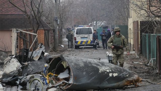 A soldier walks past the debris of a military plane that was shot down overnight in Kiev, Ukraine, 25 February 2022