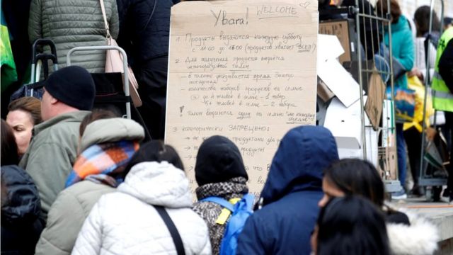 A sign points Ukrainian refugees in the direction of a food distribution centre in Zurich, Switzerland, 23 April 2022