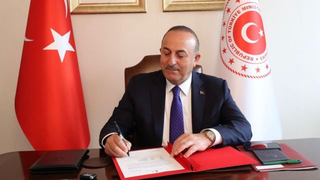 Turkish Foreign Minister Mevlut Cavusoglu signing a document