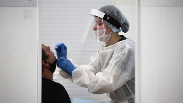A medical professional conducts a nasal swab