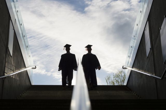 Silhouette of Two College Graduates Climbing Steps