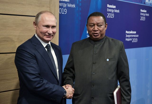 Russia's president Putin and OPEC Secretary General Mohammad Barkindo shaking hands.