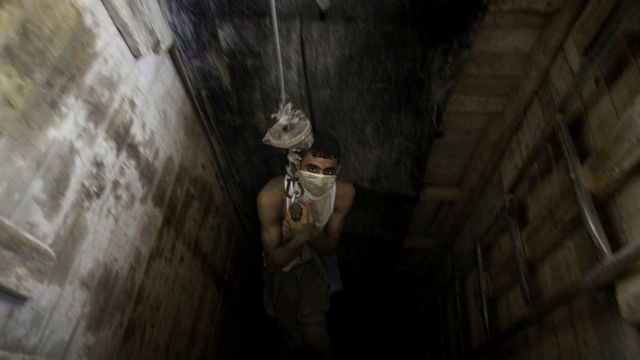 Palestinian man in tunnel entrancde on winch